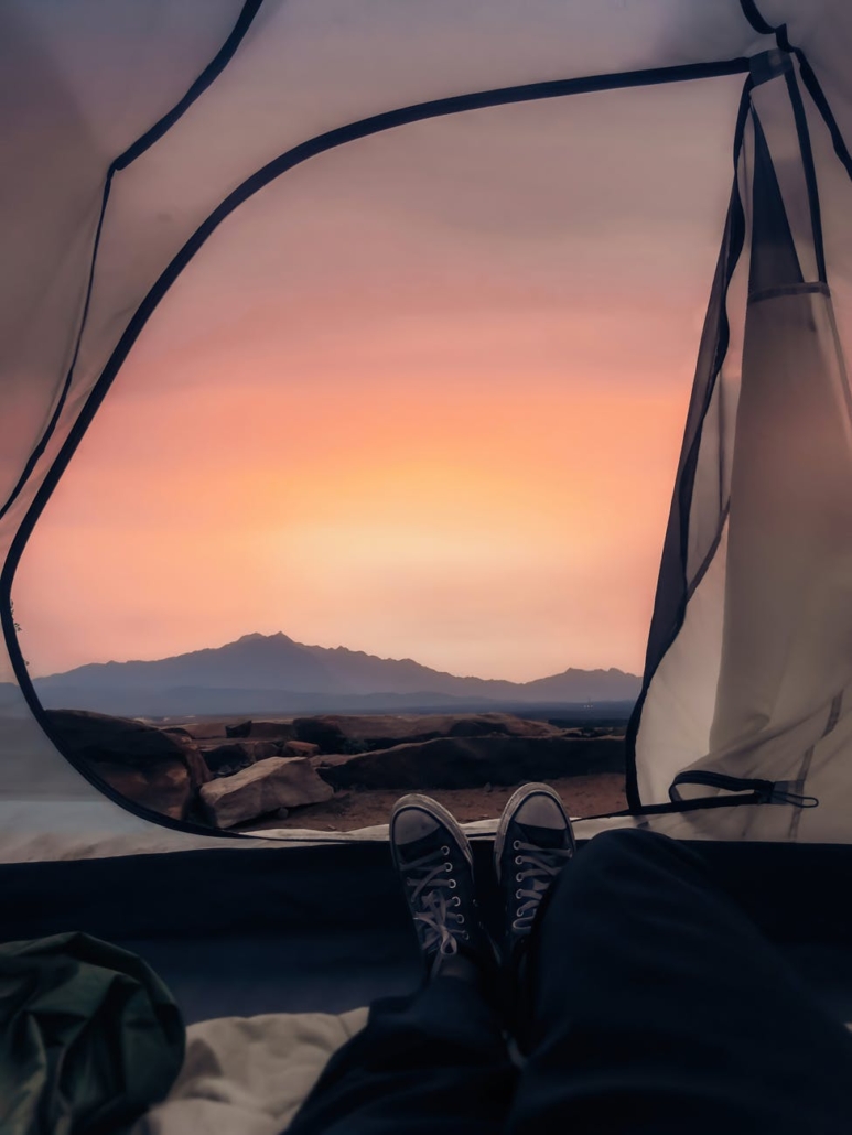 traveler lying in tent and enjoying bright sunset light